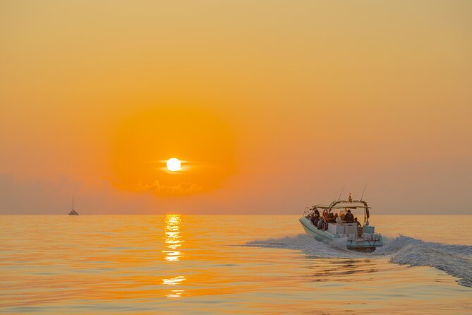 Dolphin watching by boat - Sunrise and the Cap de Formentor setting