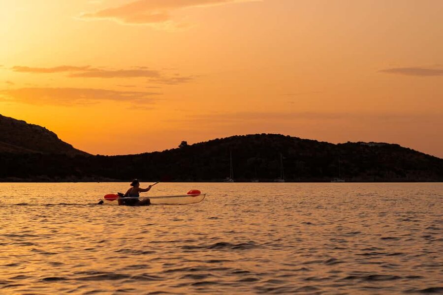 Golfo Aranci: traditional or transparent kayaks, dolphins, and aperitifs - Paddling across clear water toward Cala Moresca